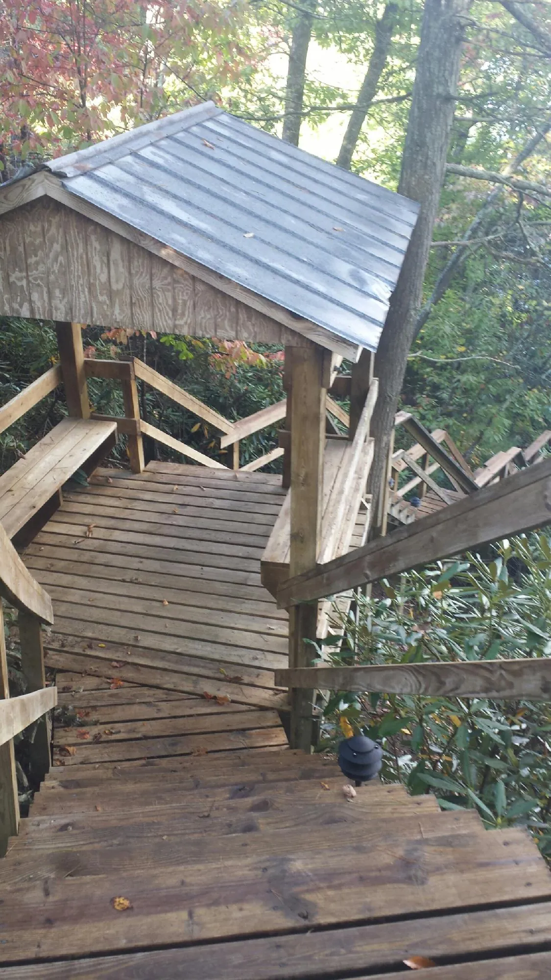 Metal roofed shelter over wooden steps on a wooded walkway — Skylight Repair & Installation work by our crew in Tornado