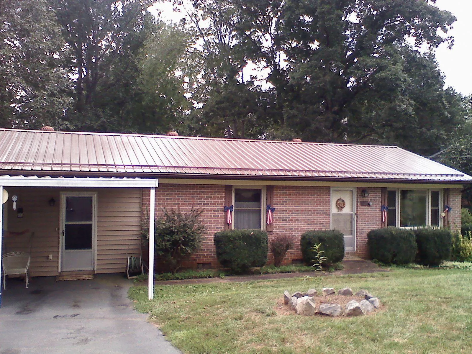 Bronze metal roof and carport on a brick ranch home — Roof Repair work by our crew in Tornado